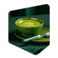 Bol de potage vert aux courgettes Pocket Soupe garni de graines, servi avec une cuillère sur une nappe verte