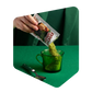 Poudre de potage aux courgettes Pocket Soupe versée d'un sachet dans une tasse de verre vert
