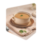 Bol de velouté aux oignons caramélisés Pocket Soupe garni d'une feuille de sauge, servi sur une nappe beige