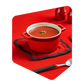 Cocotte rouge remplie de soupe aux tomates Pocket Soupe garnie de persil, posée sur un carré de laine tricoté