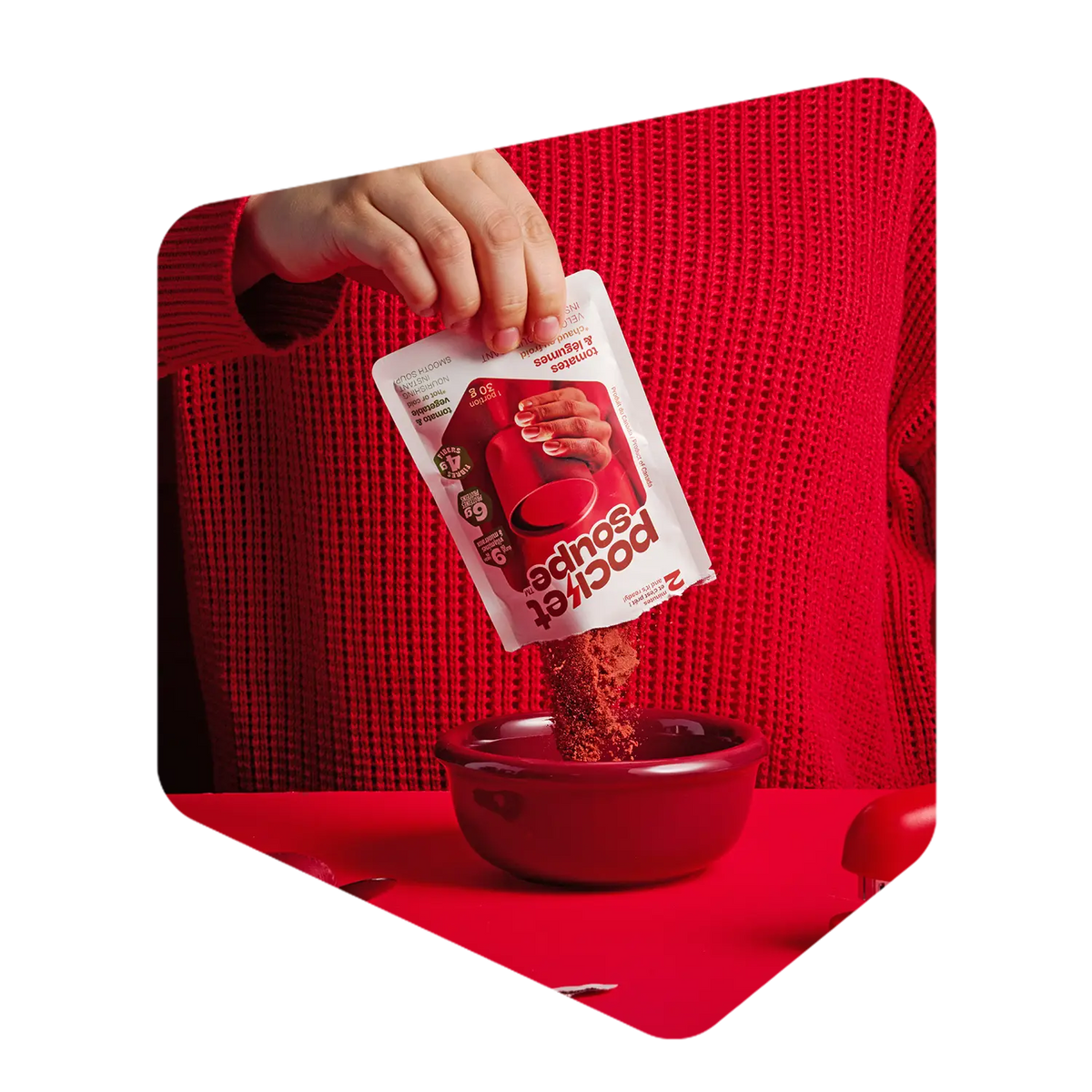Poudre de soupe aux tomates Pocket Soupe versée d'un sachet dans un bol rouge
