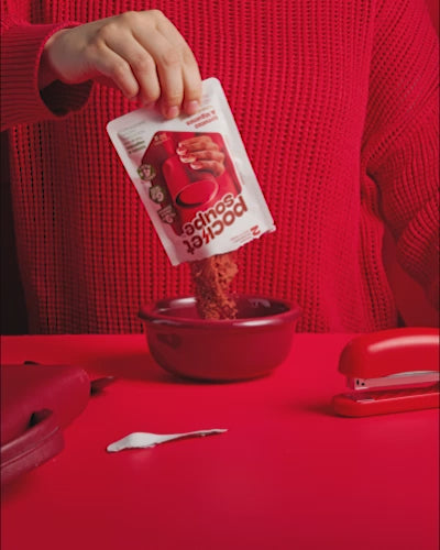 Quelqu'un verse un sachet de pocket soupe dans un bol et ajoute de l'eau bouillante